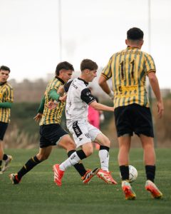 Dynamic shot capturing teenage soccer players competing fiercely on the field.